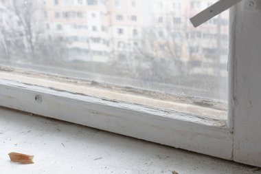 Tahta pencere ve beyaz yatay panjurlar. Eski bir ahşap pencerenin parçası ve kirli eski bir pencere pervazı..