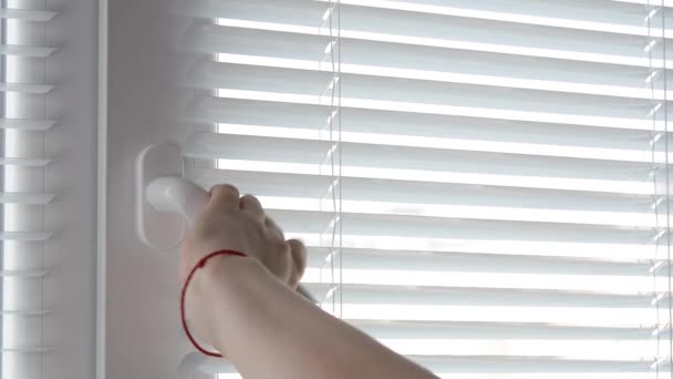 A woman open White Plastic Window By The Handle and close blinds. — Stock Video