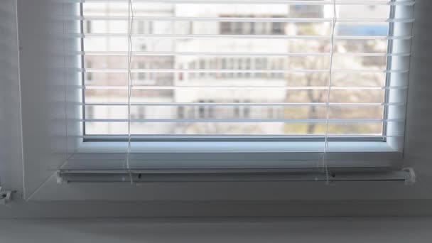 Женщина открывает и закрывает жалюзи на окне в его комнате — стоковое видео