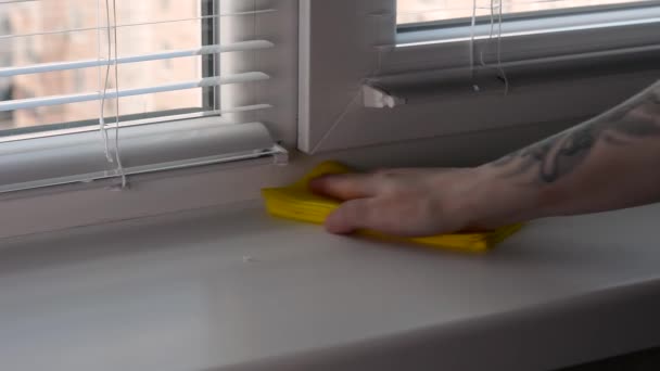 La mano de la mujer quita pedazos de escombros del alféizar de la ventana y limpia el polvo del alféizar de la ventana con un trapo amarillo. — Vídeos de Stock