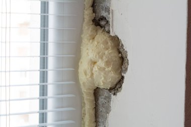 Pencere kurulumu. Pencerenin yamacında poliüretan köpük var. Pencere eğimleri mühürleniyor.