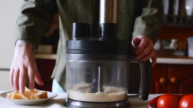 İsimsiz biri blender 'a peynir sürüyor.