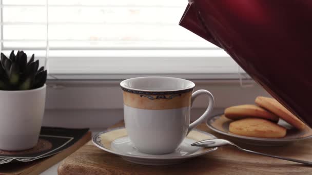 İsimsiz biri kırmızı çaydanlıktan kaynayan suyu bir fincan hazır kahveye döker. — Stok video