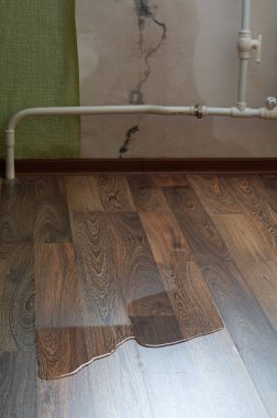 Dairenin duvarında çatlak var. Yağmurdan gelen su duvardaki bir çatlaktan daireye akıyor. Sızdıran su, lamine zeminde akıyor.