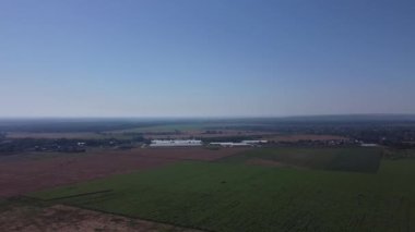 Hava sineması klibi: İnsansız hava aracı bir tarla ve şehir üzerinde uçuyor.