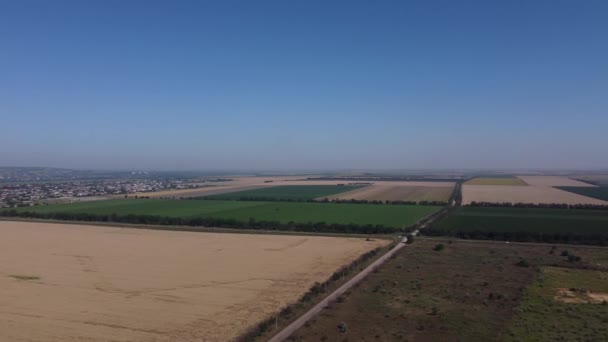 Letecký filmový klip: Dron letící nad poli a městem. — Stock video