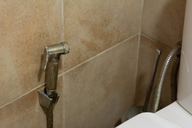 Tuvalet banyosunda kireç, beyaz tebeşir, leke ve pas dolu el yapımı bidet spreyi..