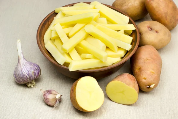 Batatas em um prato de barro e alho — Fotografia de Stock