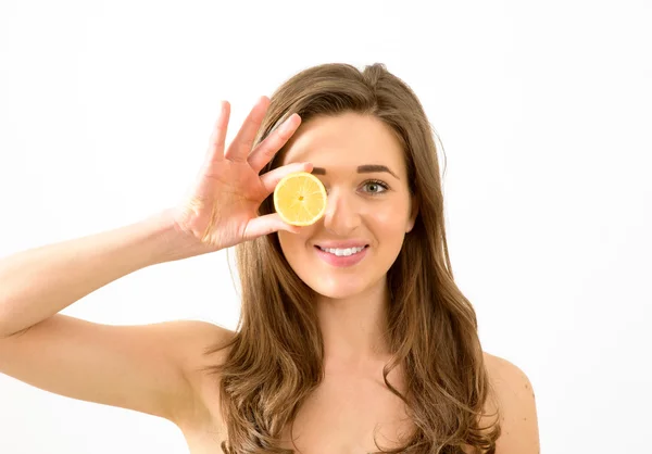 Uśmiechnięta kobieta gospodarstwa cytryny do twarzy — Zdjęcie stockowe