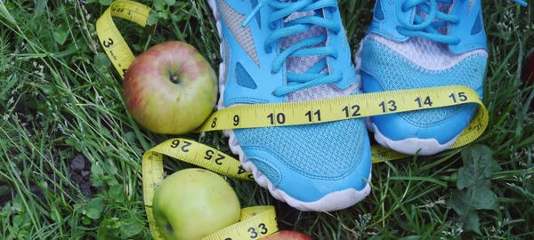 Turnschuhe, Zentimeter, rote Äpfel, Gewichtsverlust, Laufen, gesunde Ernährung, gesunder Lebensstil — Stockfoto