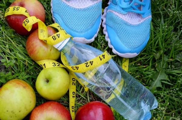 Turnschuhe, Zentimeter, rote Äpfel, Gewichtsverlust, Laufen, gesunde Ernährung, gesunder Lebensstil — Stockfoto