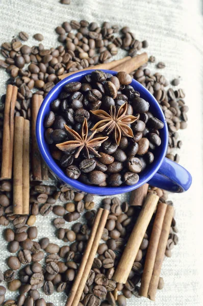 Cup full of coffee beans, cinnamon sticks, star anise, closeup — Stock Photo, Image