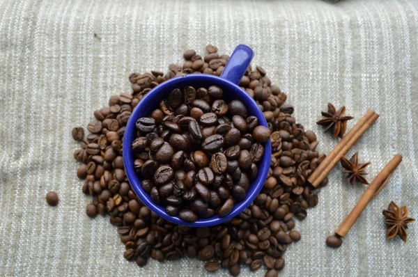 Copo cheio de grãos de café, paus de canela, anis estrelado, close-up — Fotografia de Stock