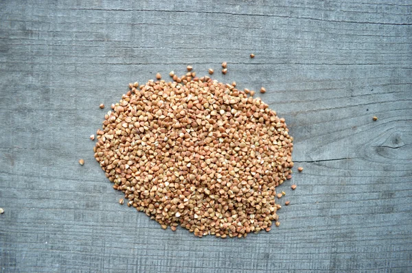 Primo piano di grano saraceno su sfondo di legno — Foto Stock