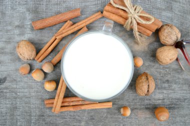 Tarçın, baharat ve fındık, ceviz, closeup ahşap arka plan üzerinde sıcak süt fincan