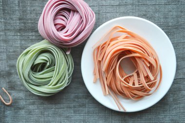 Ahşap arka plan üzerinde renkli ham İtalyan makarna