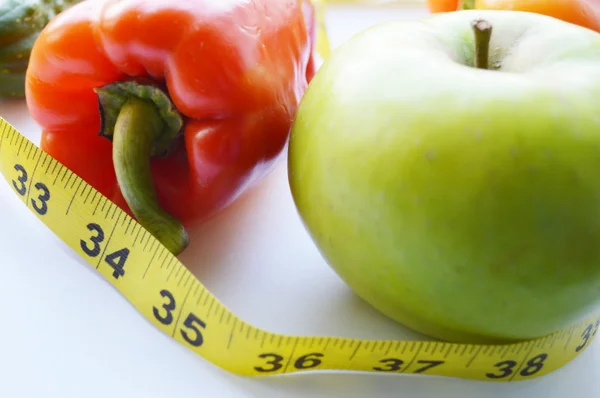 Legumes e frutas para perda de peso, uma fita métrica, dieta, perda de peso — Fotografia de Stock