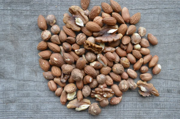 Valnötter, mandlar, hasselnötter närbild på trä bakgrund, många sorters nötter — Stockfoto