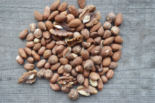 Valnötter, mandlar, hasselnötter närbild på trä bakgrund, många sorters nötter — Stockfoto