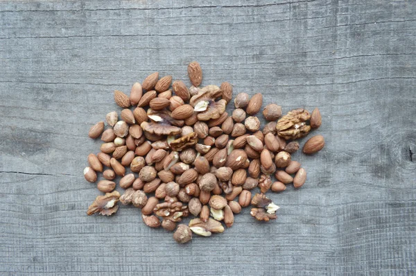 Walnuts,almonds,hazelnuts closeup on wooden background,many varieties of nuts — Stock Photo, Image