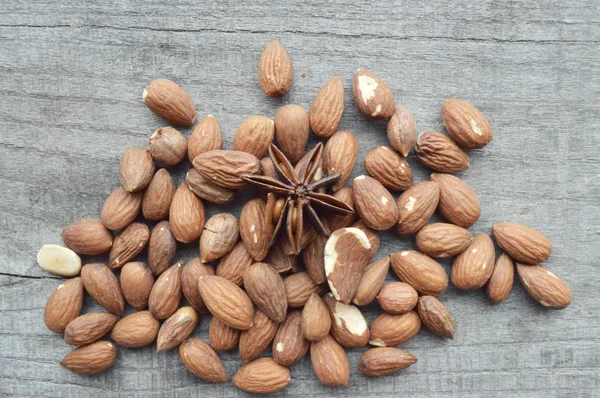 Almonds and anise on wooden table — Stock Photo, Image