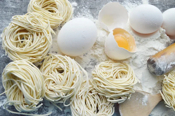 Stilleben med raw hemgjord pasta och ingredienser för pasta... processen för matlagning pasta — Stockfoto