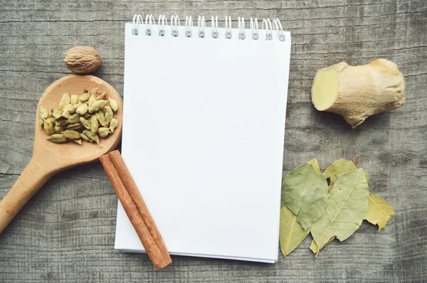 Condimentos, especias, libro de recetas, Bloc de notas, escribir, pimienta, guisantes, pimiento rojo, pimienta negra, cardamomo, anís estrellado, canela, cilantro, palitos de canela, clavo de olor, estrella — Foto de Stock