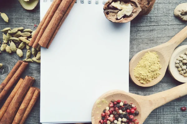 Seasonings,spices,recipe book,Notepad,write,pepper, peas,red pepper,black pepper,cardamom,star anise,cinnamon,coriander,cinnamon sticks,cloves,star — Stock Photo, Image