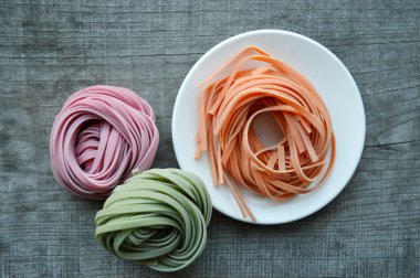 Ahşap arka plan üzerinde renkli ham İtalyan makarna