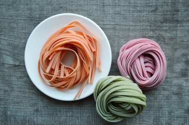 Ahşap arka plan üzerinde renkli ham İtalyan makarna