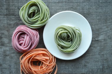 Ahşap arka plan üzerinde renkli ham İtalyan makarna