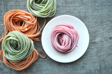 Ahşap arka plan üzerinde renkli ham İtalyan makarna