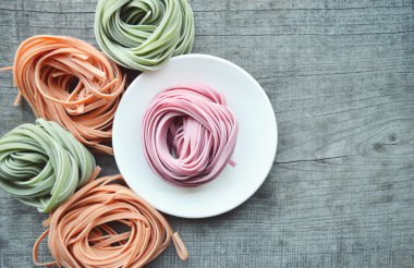 Ahşap arka plan üzerinde renkli ham İtalyan makarna