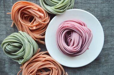 Ahşap arka plan üzerinde renkli ham İtalyan makarna