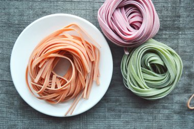 Ahşap arka plan üzerinde renkli ham İtalyan makarna