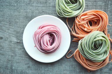 Ahşap arka plan üzerinde renkli ham İtalyan makarna