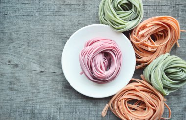 Ahşap arka plan üzerinde renkli ham İtalyan makarna