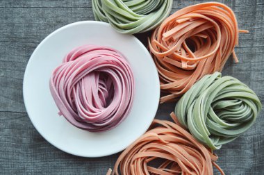 Ahşap arka plan üzerinde renkli ham İtalyan makarna