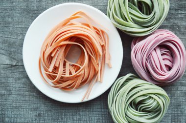 Ahşap arka plan üzerinde renkli ham İtalyan makarna