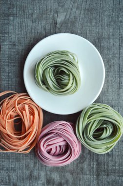 Ahşap arka plan üzerinde renkli ham İtalyan makarna