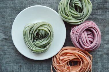 Ahşap arka plan üzerinde renkli ham İtalyan makarna