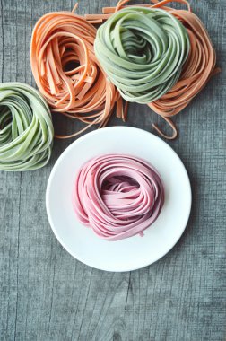 Ahşap arka plan üzerinde renkli ham İtalyan makarna