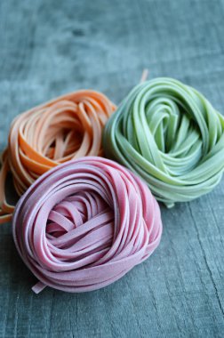 Ahşap arka plan üzerinde renkli ham İtalyan makarna