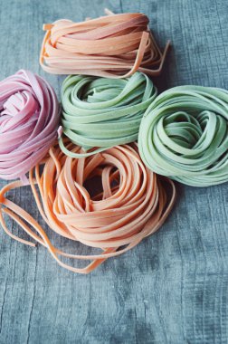 Ahşap arka plan üzerinde renkli ham İtalyan makarna