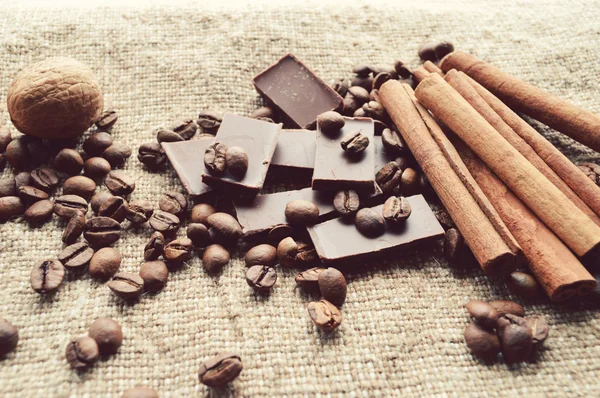 Tarçın, çikolata, kahve, karanfil, arka plan çuval bezi üzerinde Fındık ceviz — Stok fotoğraf