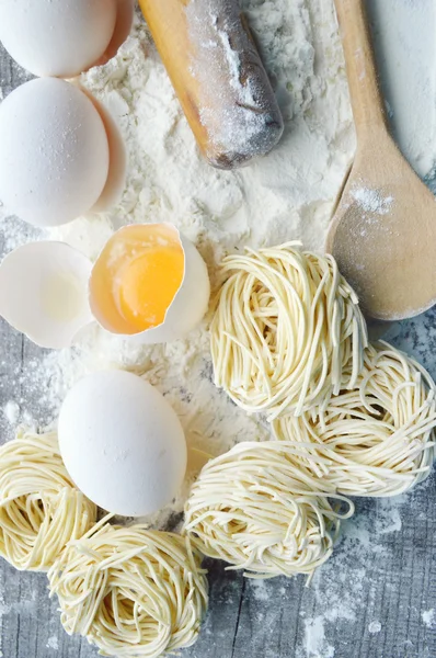 Stilleven met ruwe huisgemaakte pasta en ingrediënten voor pasta... proces van koken pasta — Stockfoto