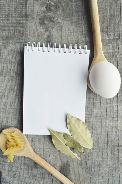 Livro de receitas, Bloco de notas, cozinhar, especiarias em fundo de madeira — Fotografia de Stock