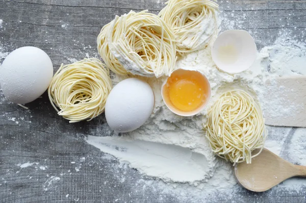 Natura morta con pasta cruda fatta in casa e ingredienti per la pasta.. processo di cottura della pasta — Foto Stock
