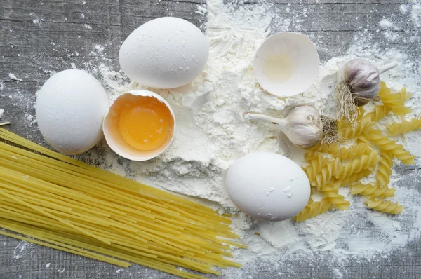 Natura morta con pasta cruda fatta in casa e ingredienti per la pasta.. processo di cottura della pasta — Foto Stock