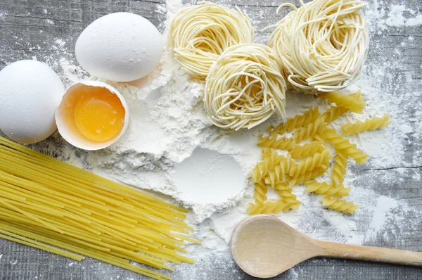 Nature morte avec des pâtes maison crues et des ingrédients pour les pâtes.. processus de cuisson des pâtes — Photo